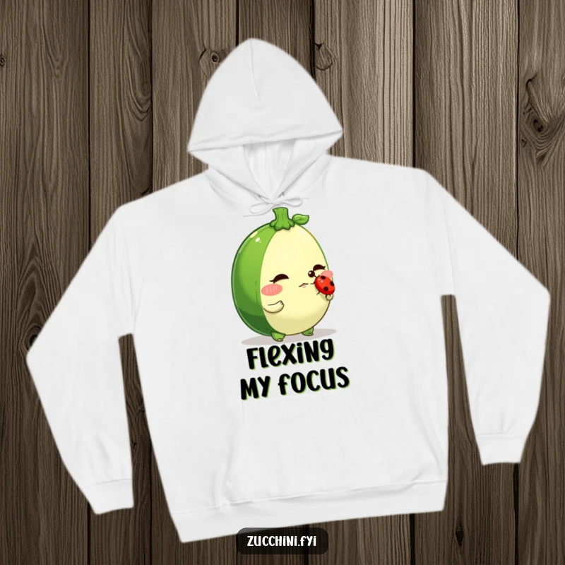 Funny zucchini hoodie, a determined veggie character balancing a ladybug on its nose, cozy and humorous for focus.