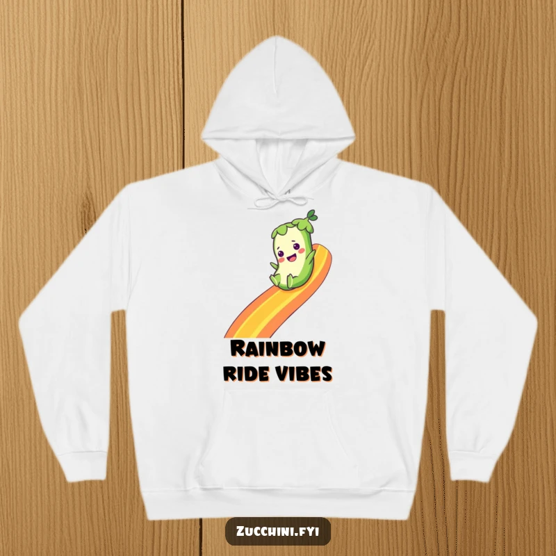 Funny hoodie with a zucchini character joyfully sliding down a bright rainbow, offering warmth and a splash of whimsical cheer.