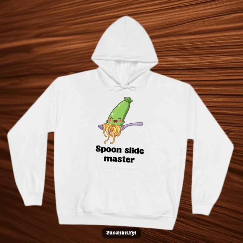 Funny hoodie illustrating a happy zucchini noodle character in a playful slide down a shiny spoon, offering cozy and comedic vibes.
