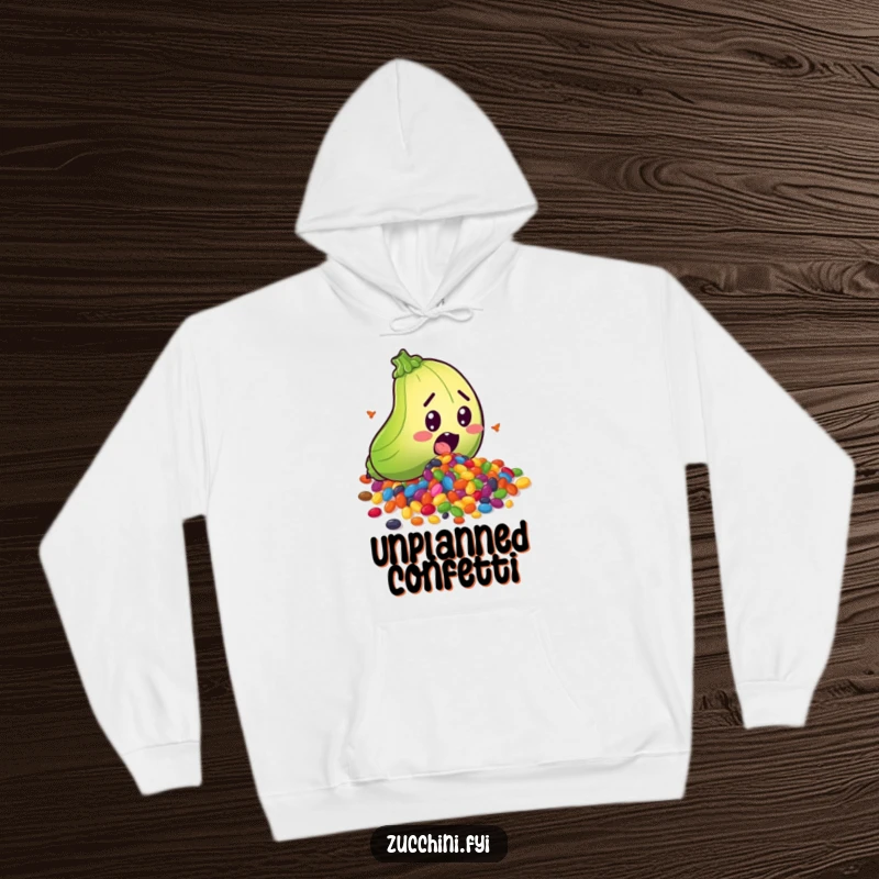 Funny hoodie showcasing a surprised zucchini character tripping and spilling a vibrant rainbow of seeds, perfect for cozy days filled with humor.