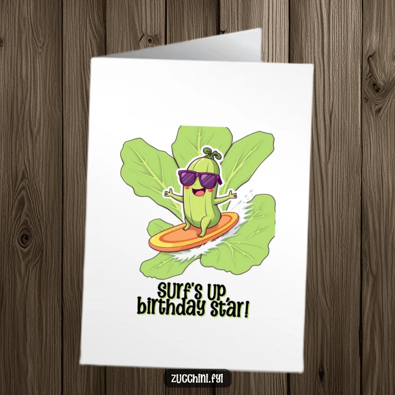 Funny Free Printable birthday card featuring a giggling zucchini in sunglasses surfing a lettuce leaf, ready to party.